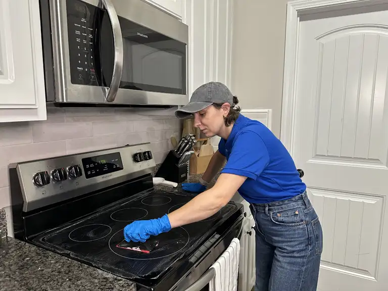 Bozman Cleaning team member cleaning a glass cooktop